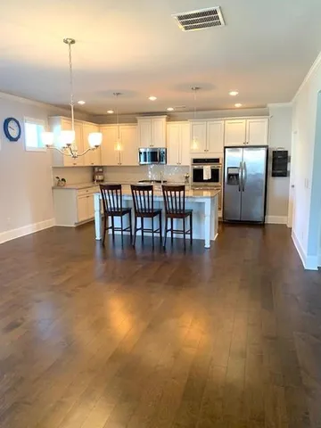 a view of kitchen with kitchen island stainless steel appliances refrigerator stove microwave and cabinets