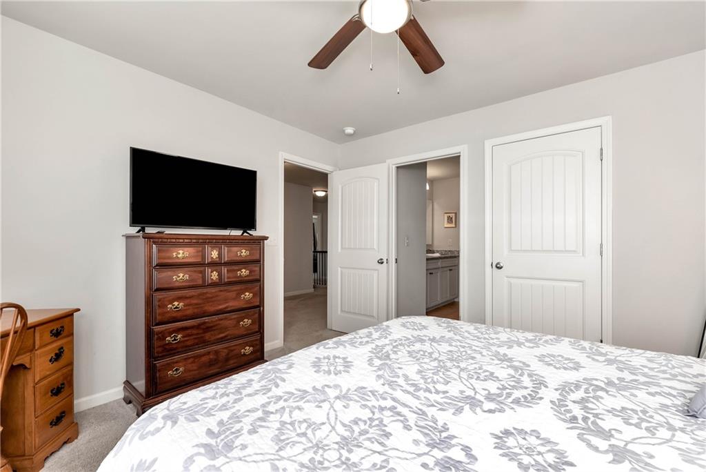 253 Orchard Trail Canton, GA 30115 - Photo 23 of 40 a bedroom with a bed and a flat tv screen on dresser