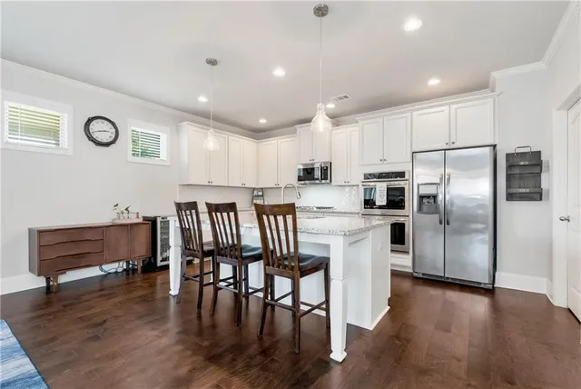 a kitchen with granite countertop a refrigerator and wooden floors