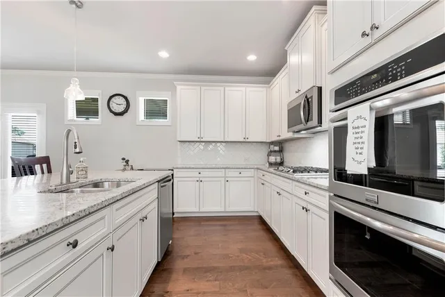 a kitchen with granite countertop white cabinets and white appliances