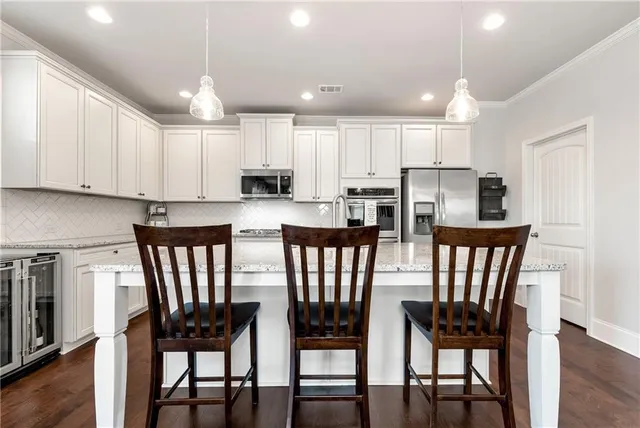 a view of kitchen with dining table chairs cabinets and stainless steel appliances