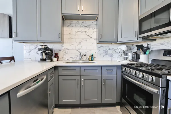 a kitchen with stainless steel appliances white cabinets granite counter tops and a wooden floors