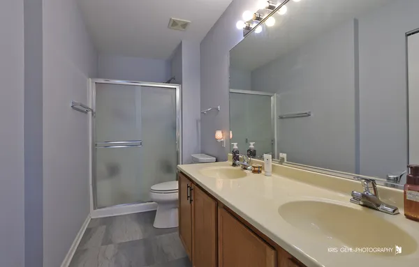 a bathroom with a sink vanity granite toilet and a mirror