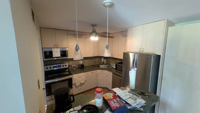 a room with furniture a flat screen tv and a refrigerator