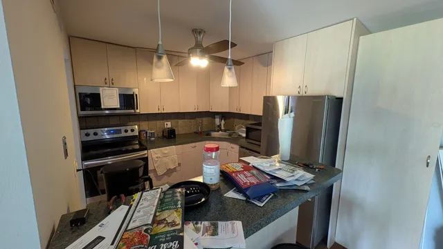 a kitchen with stainless steel appliances a stove refrigerator and microwave