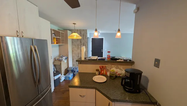 a bathroom with a granite countertop sink and a refrigerator
