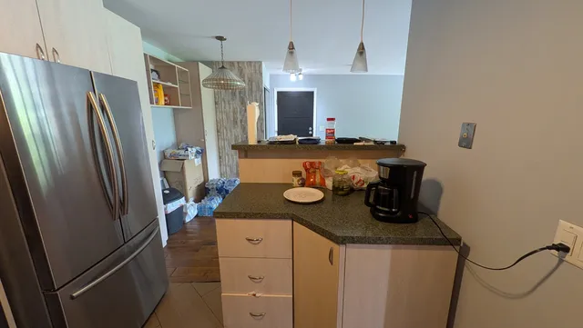 a kitchen with a sink and a stove with wooden floor
