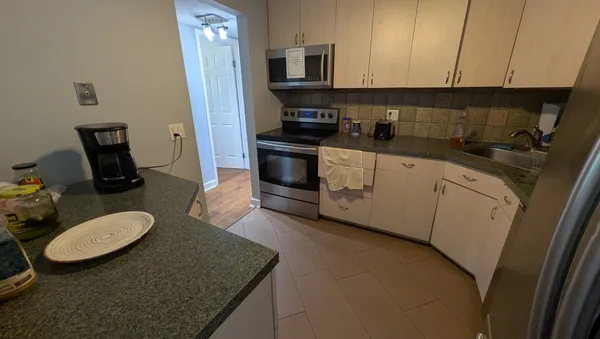 a kitchen with sink a microwave a stove and cabinets