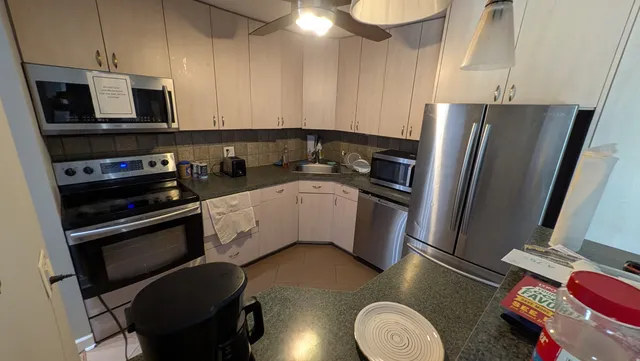 a kitchen with appliances a sink and cabinets