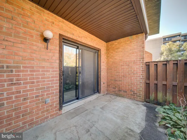 a view of an empty room with wooden floor and a fireplace