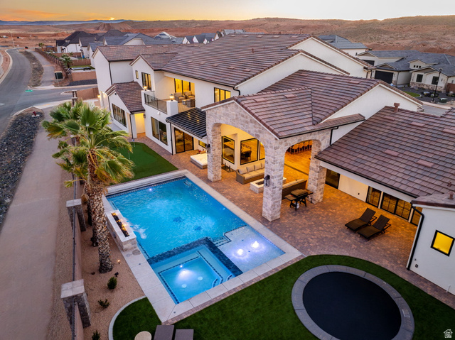 4871 South Homestead Way Washington, UT 84780 - Photo 144 of 151 Pool at dusk with a patio, a pool with connected hot tub, outdoor furniture, a residential view, and a yard