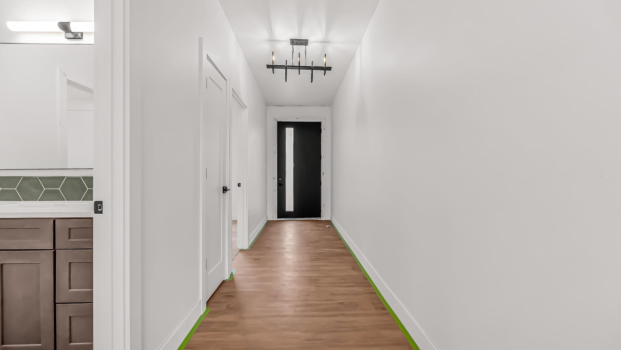 214 Limberpine Circle Parachute, CO 81635 - Photo 3 of 24 a view of a hallway with wooden floor and a chandelier