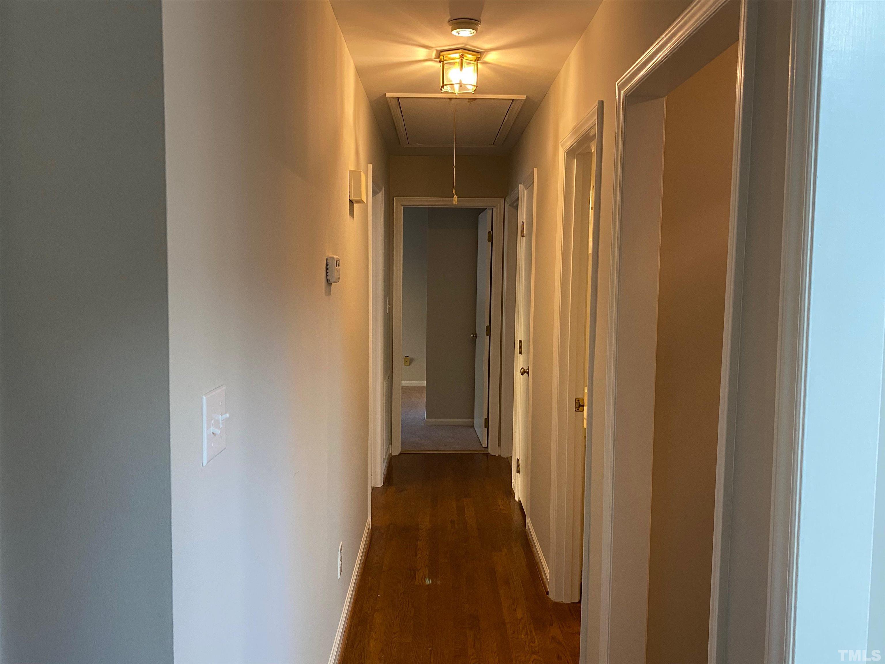 6929 Three Bridges Circle Raleigh, NC 27613 - Photo 6 of 28 a view of a hallway with wooden floor and a bathroom