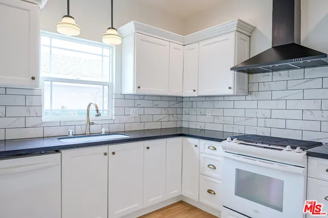 a kitchen with white cabinets and white appliances