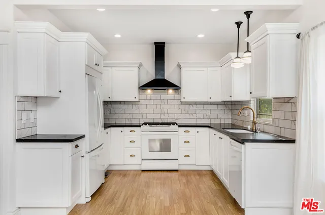 a kitchen with granite countertop a sink stove and cabinets
