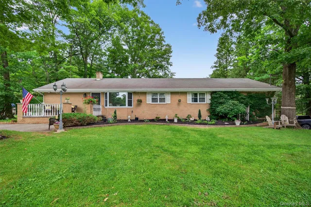 a view of a house with a big yard plants and large trees