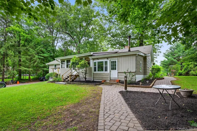 a view of a house with backyard sitting area and garden