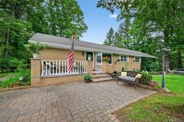 a view of a house with backyard and sitting area