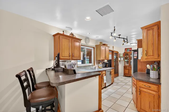 a kitchen with stainless steel appliances kitchen island granite countertop a sink and cabinets