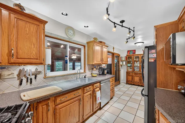 a large kitchen with a sink a counter space and stainless steel appliances