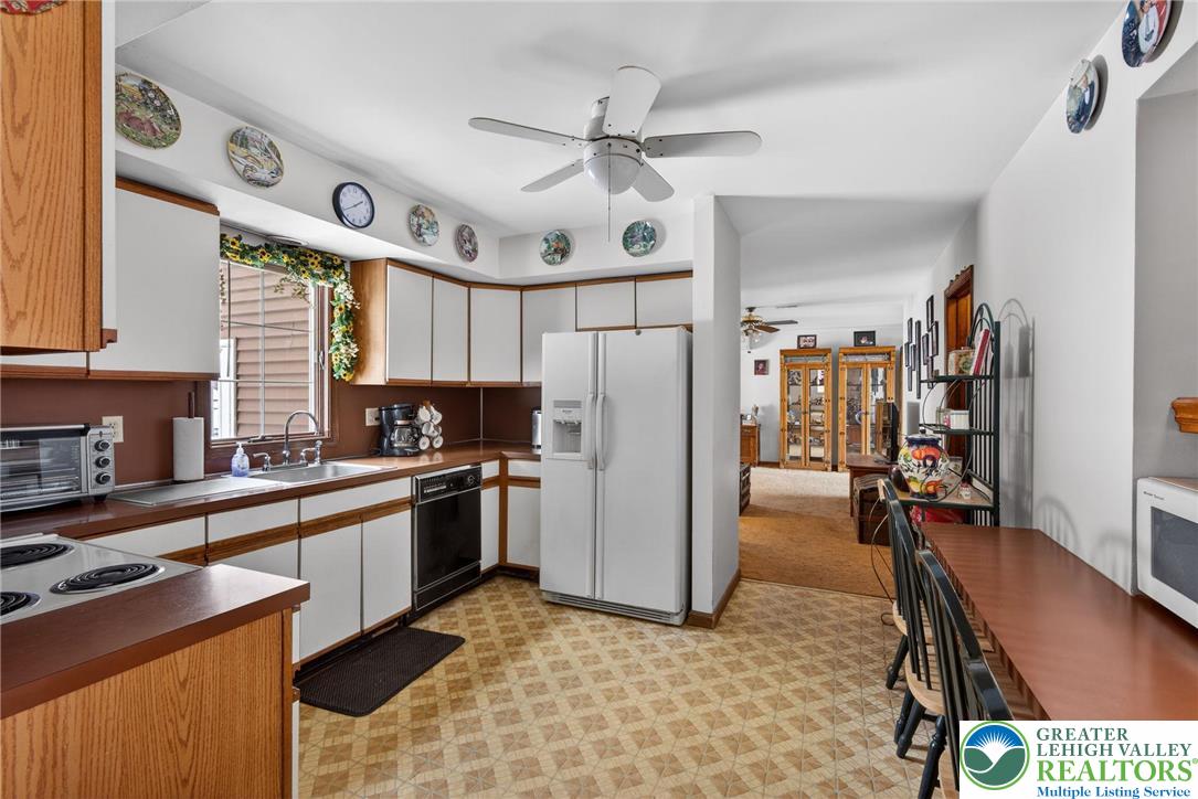 4793 Main Road West Emmaus, PA 18049 - Photo 50 of 81 a kitchen with stainless steel appliances granite countertop a refrigerator a sink dishwasher a stove and white countertops with wooden floor