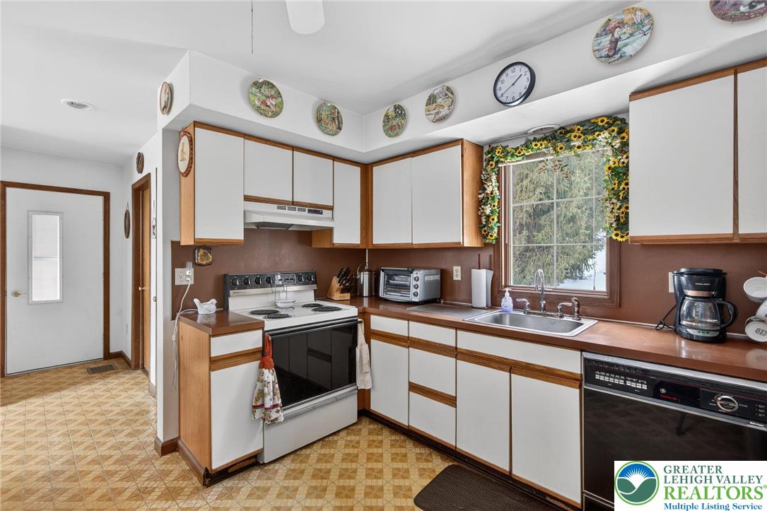 4793 Main Road West Emmaus, PA 18049 - Photo 51 of 81 a kitchen with stainless steel appliances granite countertop a stove a sink dishwasher and cabinets with wooden floor