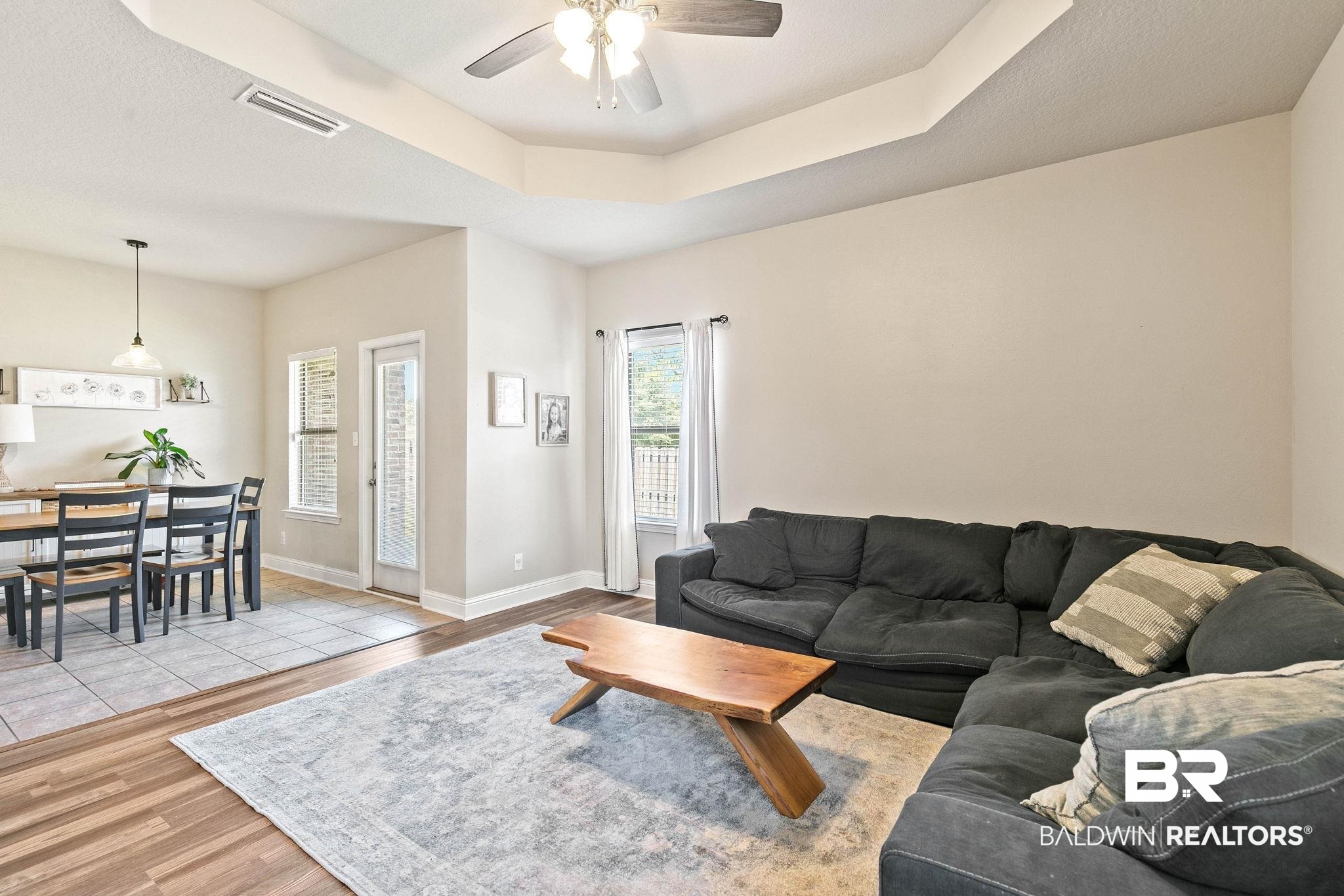 2216 Livingstone Court Mobile, AL 36695 - Photo 8 of 62 Open-concept living space featuring wood-finish flooring, a tray ceiling with a ceiling fan, and recessed lighting