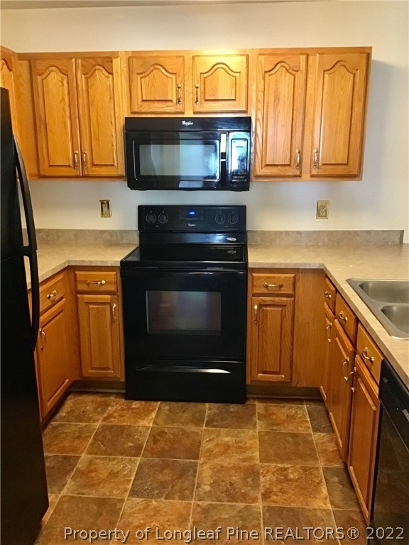 1824 Sardonyx Road, Unit 2 Fayetteville, NC 28303 - Photo 7 of 20 a kitchen with stainless steel appliances granite countertop a stove top oven microwave and cabinets