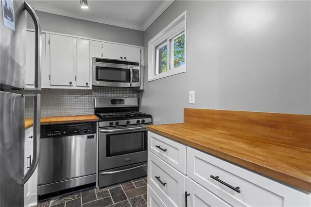 a kitchen with stainless steel appliances granite countertop a stove and a microwave