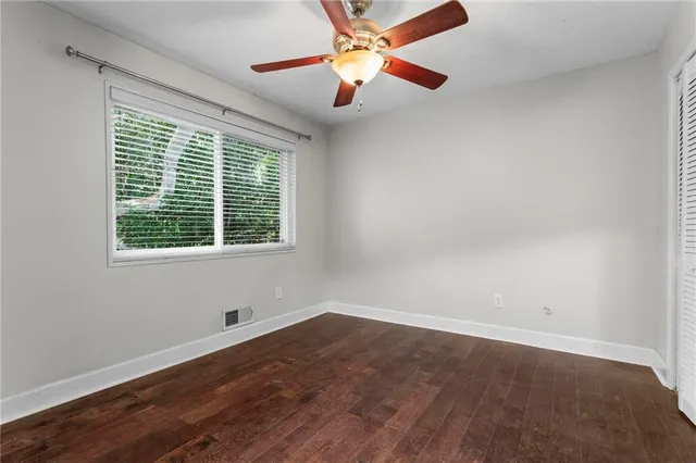 an empty room with a window and a fan