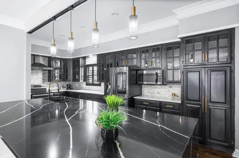 a view of a big room with windows and chandelier fan