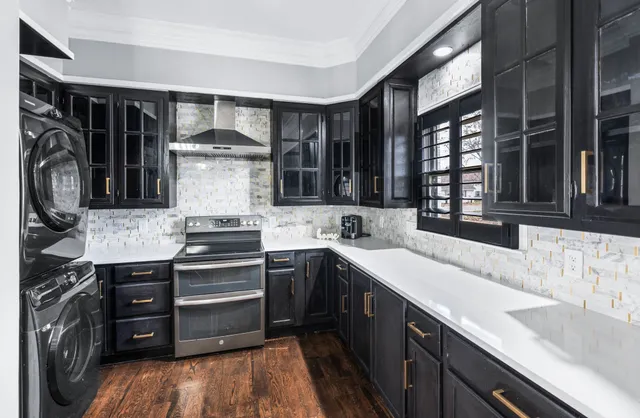 a kitchen with stainless steel appliances a stove a sink a microwave a refrigerator and cabinets