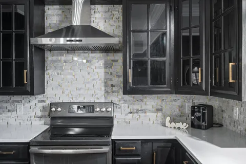 a kitchen with stainless steel appliances granite countertop a sink a stove and a refrigerator