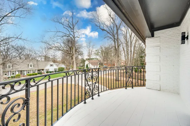 a view of a white house with large windows and a small yard