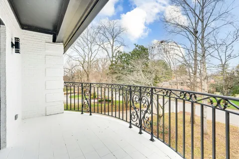 a view of large white house with a large tree