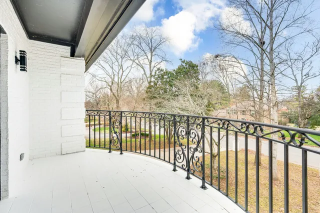 a view of large white house with a large tree