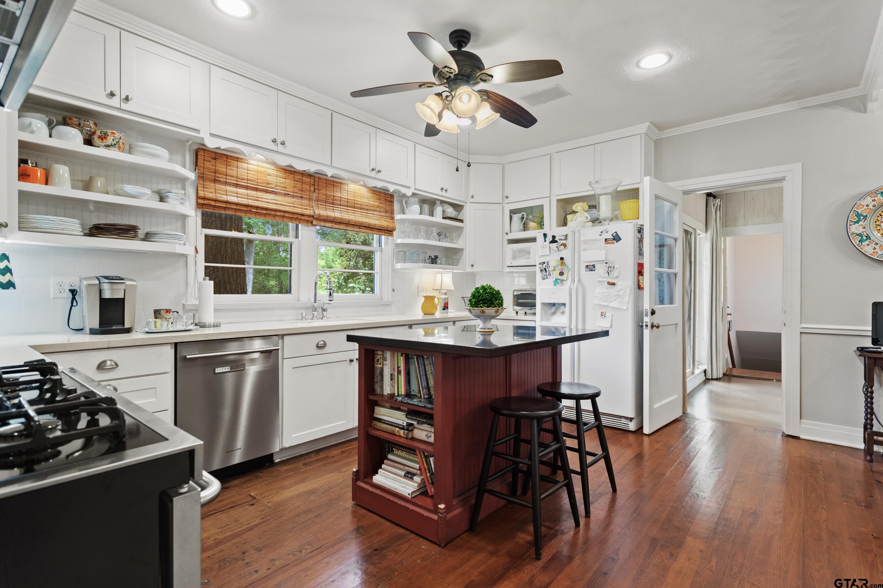 2631 Old Bullard Road Tyler, TX 75701 - Photo 27 of 43 a kitchen with stainless steel appliances a dining table chairs stove and cabinets