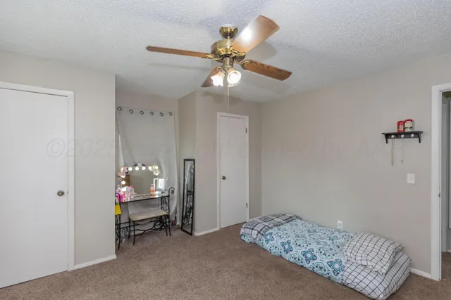 a bedroom with a bed and a chandelier fan