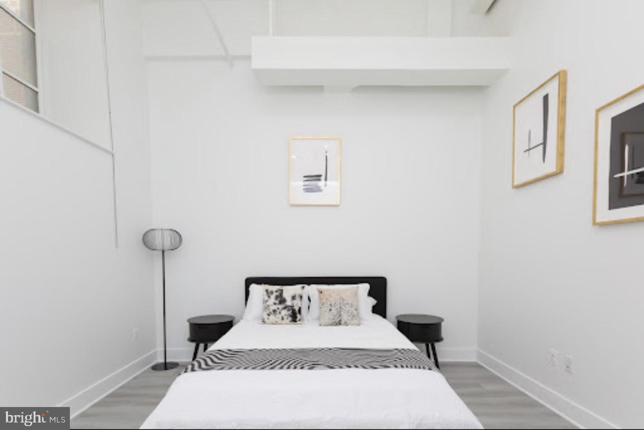300 Cathedral Street, Unit 106 Baltimore, MD 21201 - Photo 6 of 16 a bedroom with a bed and a table