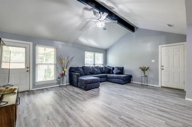 a living room with furniture and a wooden floor