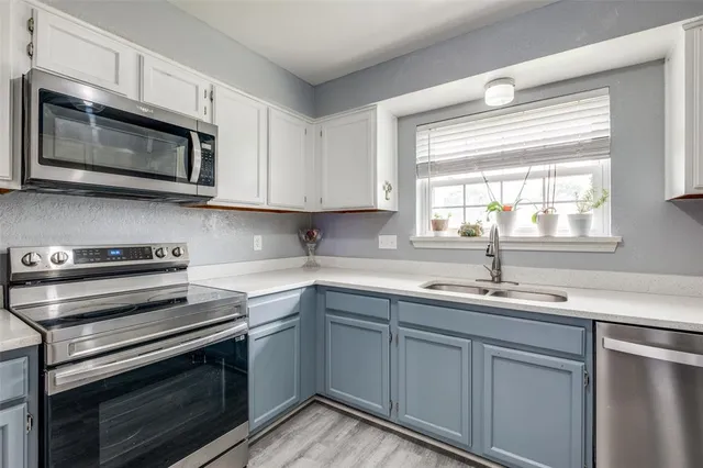 a kitchen with a sink stove and microwave