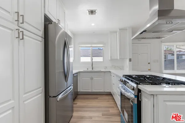 a kitchen with a refrigerator a sink and wooden cabinets