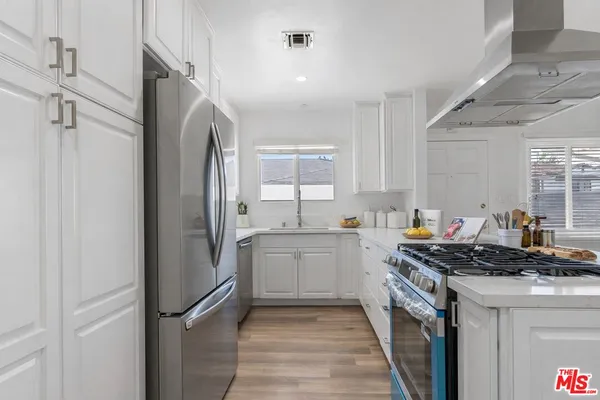 a kitchen with stainless steel appliances a refrigerator sink and stove