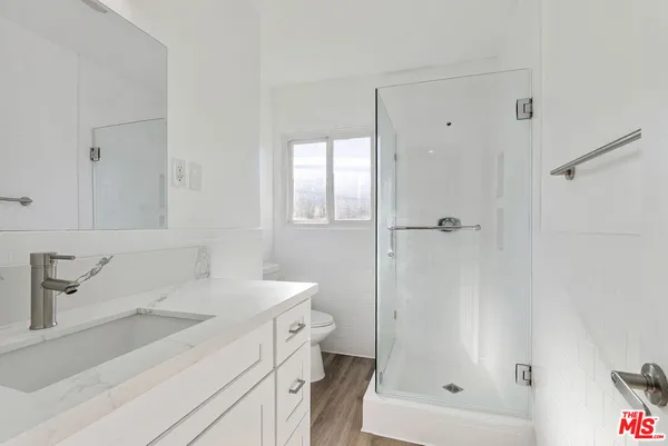 a bathroom with a sink a toilet and shower