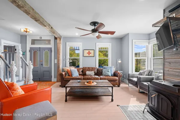 a living room with furniture a flat screen tv and a window