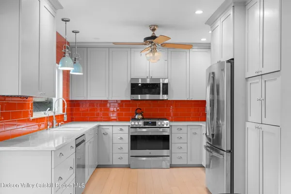 a kitchen with stainless steel appliances granite countertop a refrigerator a stove and a sink