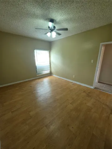 a view of an empty room with a chandelier fan