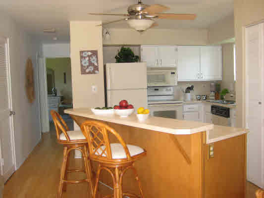3780 Edward Road, Unit 5201 Princeville, HI 96722 - Photo 15 of 23 a kitchen with stainless steel appliances granite countertop a sink refrigerator and cabinets