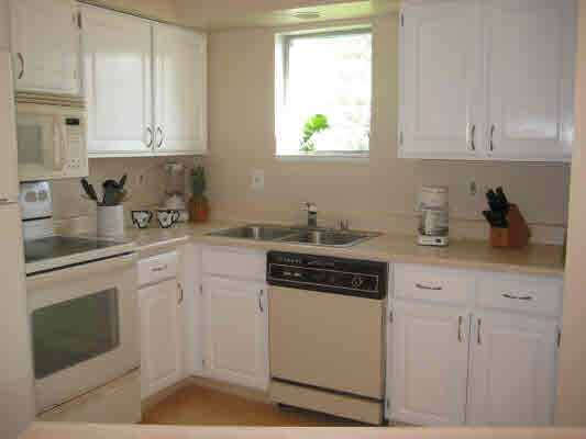 3780 Edward Road, Unit 5201 Princeville, HI 96722 - Photo 16 of 23 a kitchen with stainless steel appliances granite countertop white cabinets sink and stove