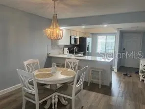 a dining room with furniture a chandelier and window